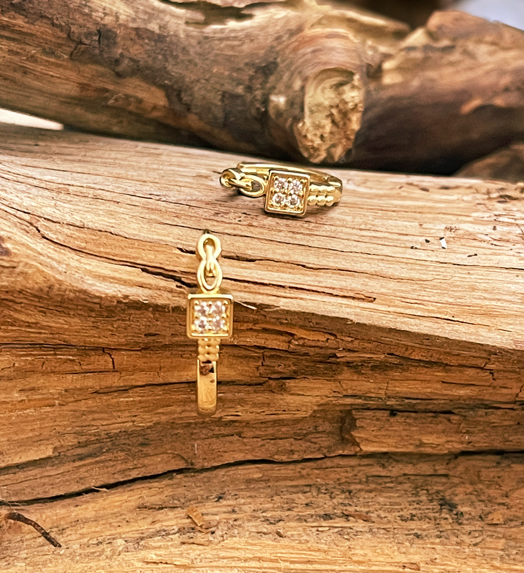 Gold jewelry pieces on a wooden surface