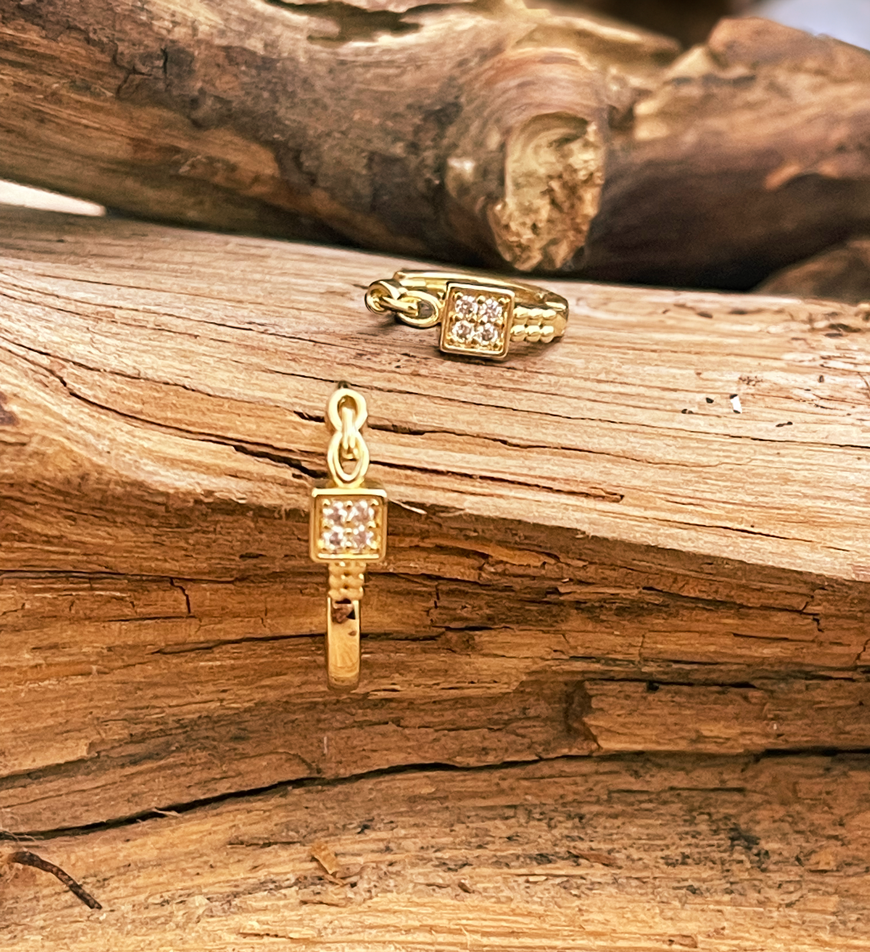 Gold jewelry pieces on a wooden surface
