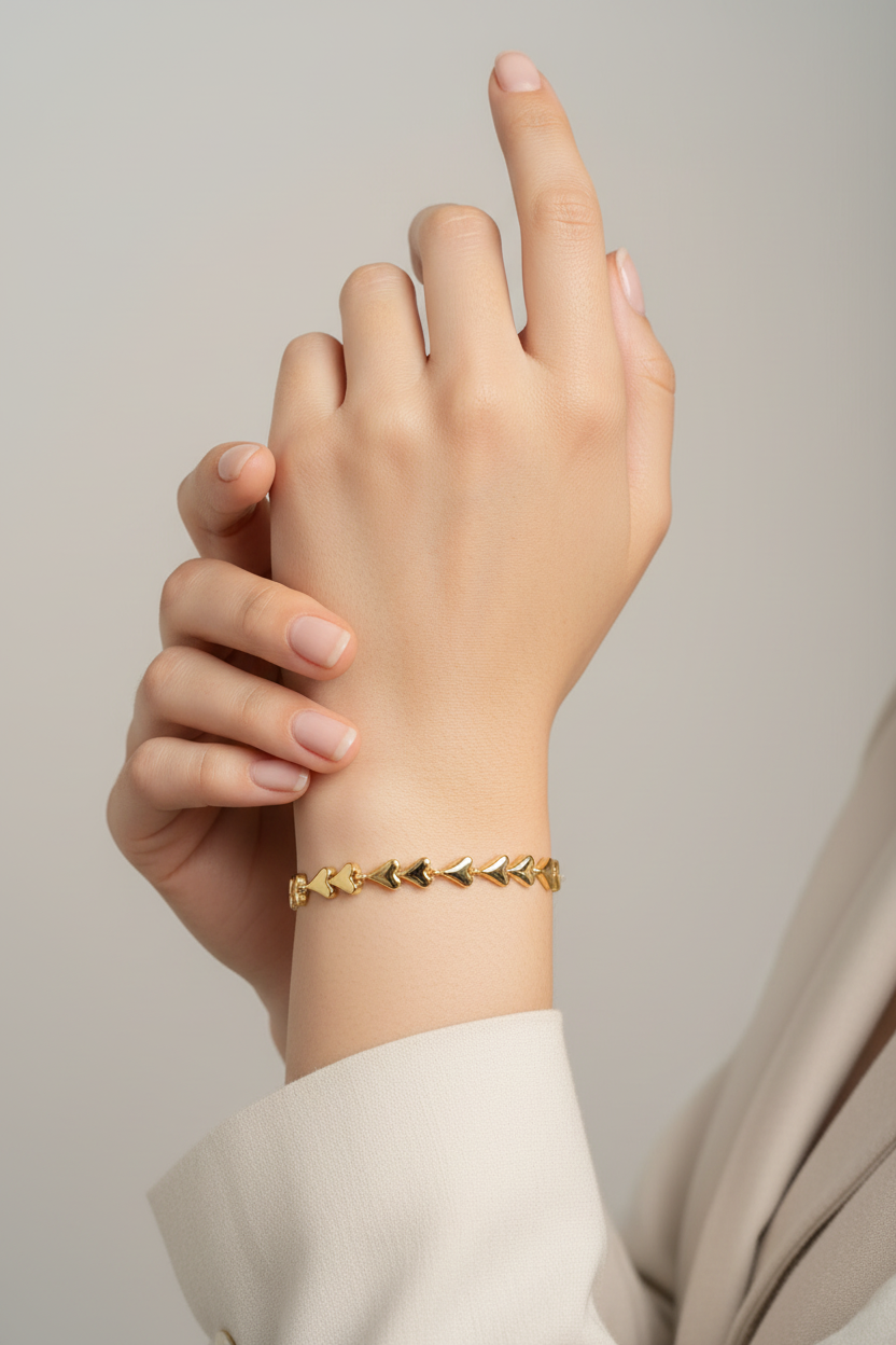 Gold bracelet on a wrist with a neutral background