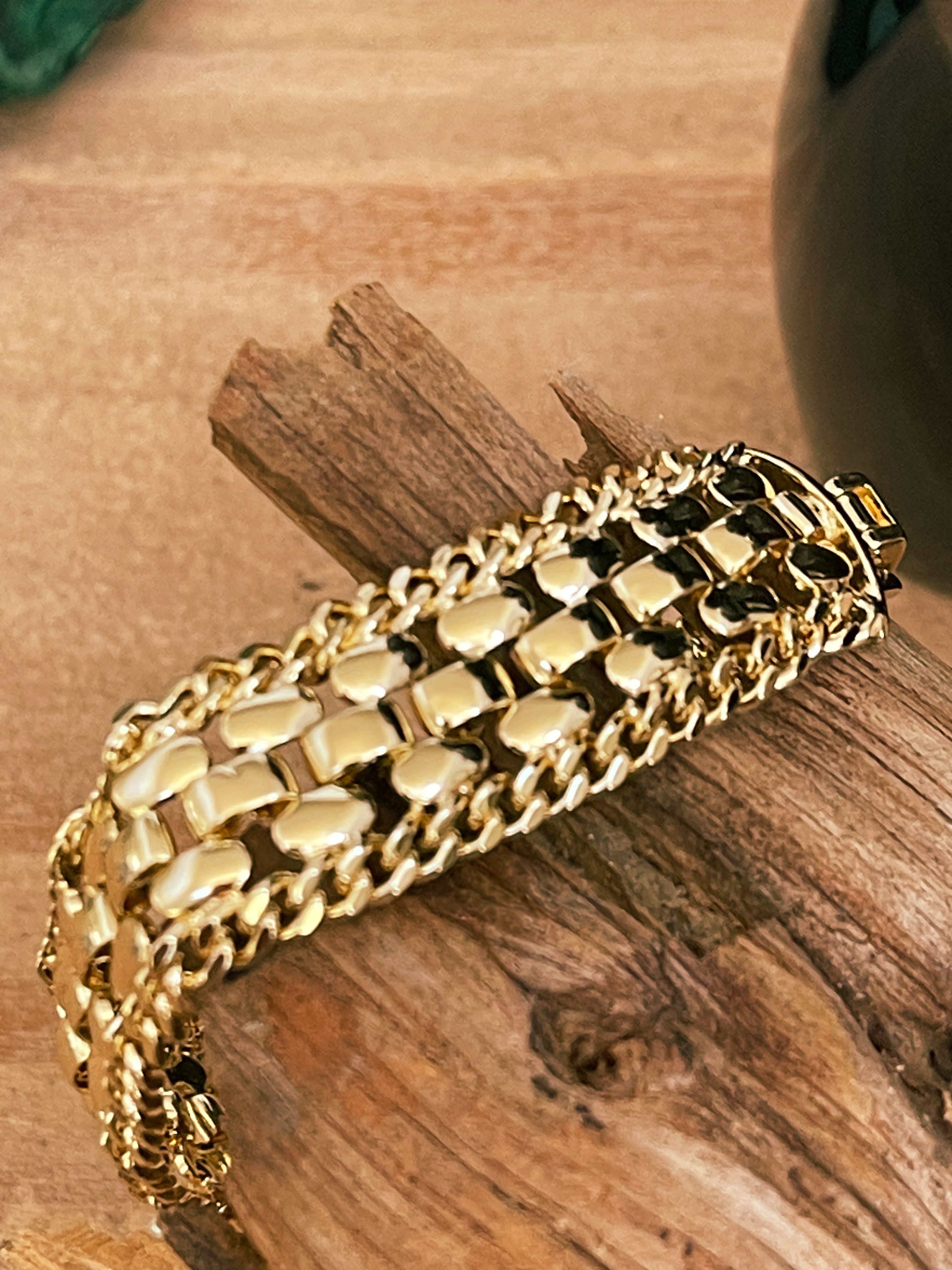 Gold chain bracelet on a wooden surface