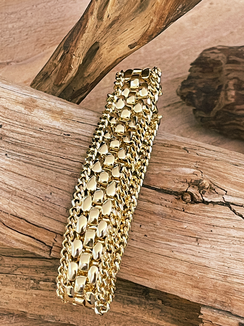Gold bracelet on a wooden surface