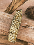 Gold bracelet on a wooden surface