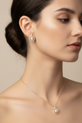 Pearl necklace and earrings set on a light gray background
