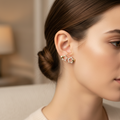 Close-up of a woman wearing gold star-shaped earrings with a blurred background